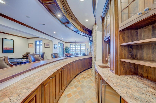 bar featuring ornamental molding, sink, a chandelier, and light stone counters