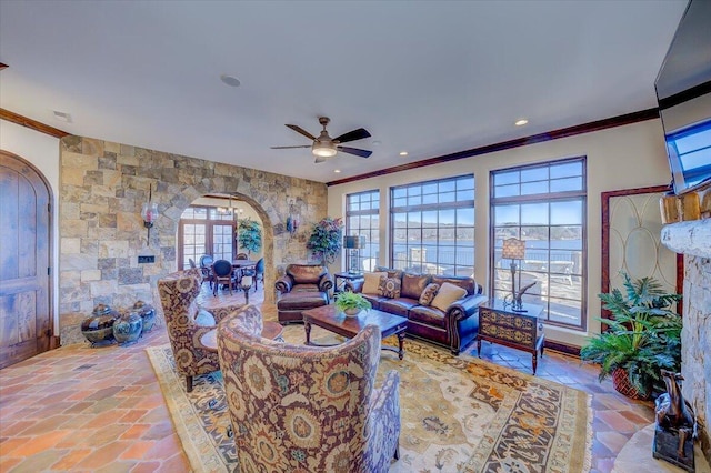 living room with ornamental molding and ceiling fan