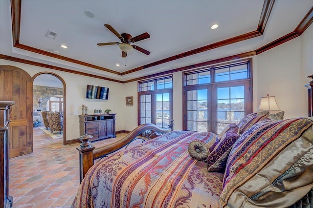 bedroom with ornamental molding and a raised ceiling