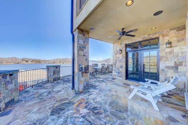 view of patio / terrace featuring french doors, ceiling fan, and a water view