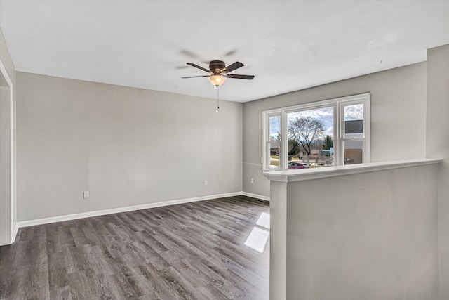 spare room with dark hardwood / wood-style flooring and ceiling fan