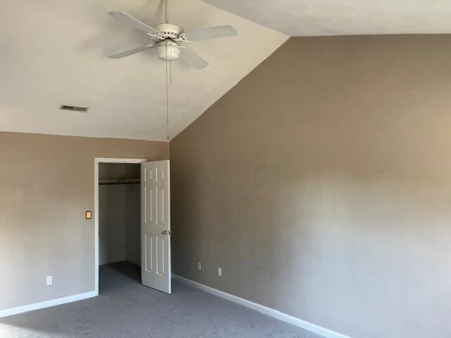 unfurnished bedroom featuring lofted ceiling, a closet, ceiling fan, and carpet flooring