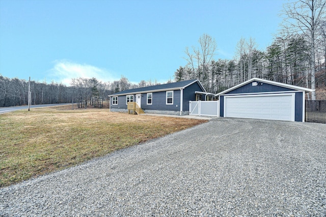 single story home with an outbuilding, a garage, and a front yard