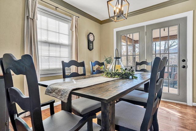 dining room featuring crown molding, an inviting chandelier, and light hardwood / wood-style flooring