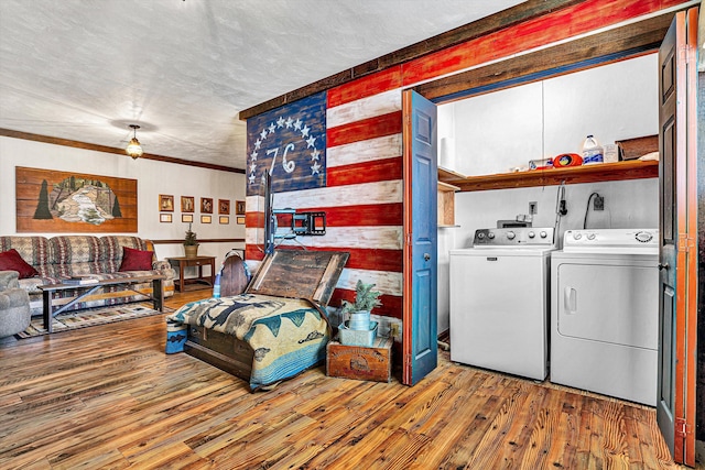 laundry area with crown molding, hardwood / wood-style flooring, independent washer and dryer, and a textured ceiling