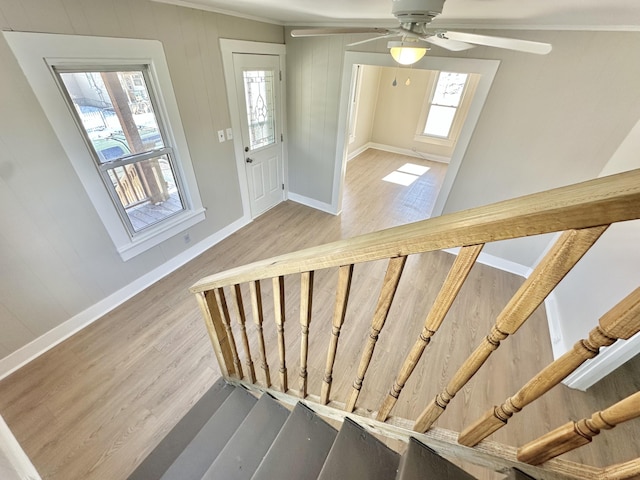 foyer entrance with light wood-style floors, a wealth of natural light, baseboards, and stairs