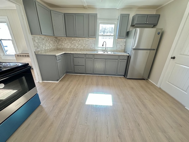 kitchen featuring light wood-style flooring, gray cabinetry, freestanding refrigerator, a sink, and black range with electric cooktop