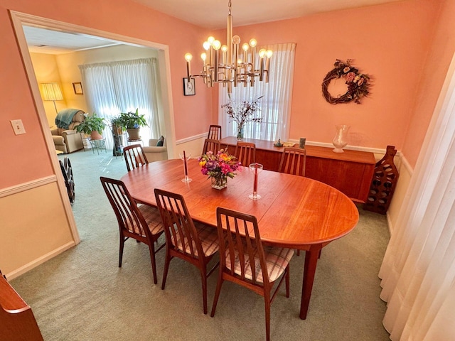 carpeted dining room featuring an inviting chandelier and a healthy amount of sunlight