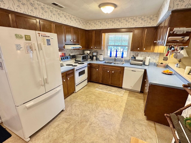 kitchen featuring tasteful backsplash, sink, and white appliances