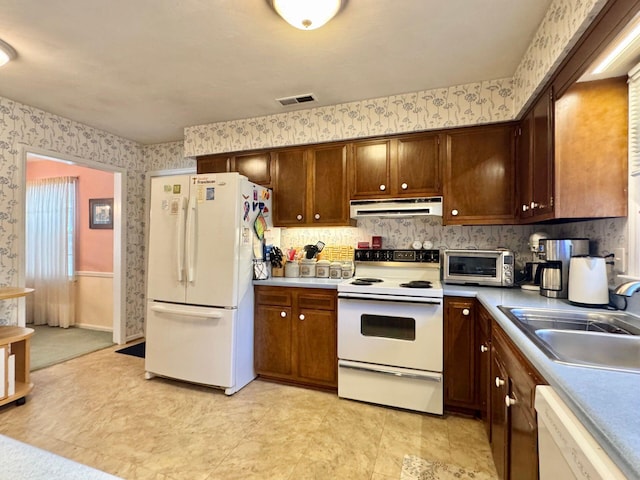 kitchen featuring white appliances and sink