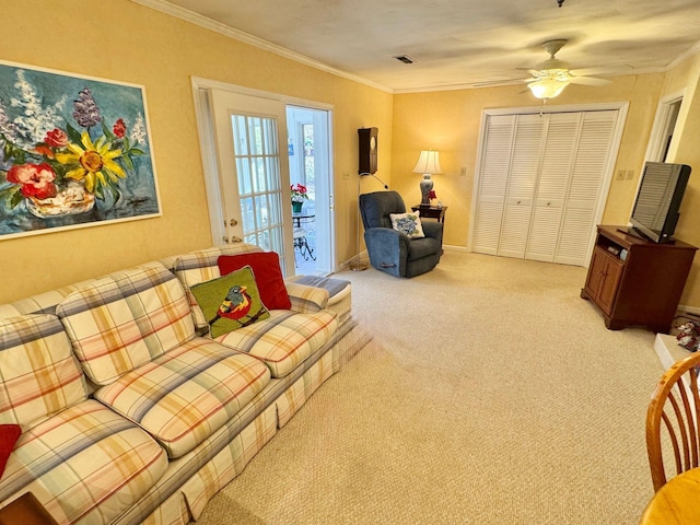 carpeted living room featuring ornamental molding and ceiling fan