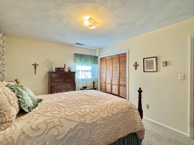 carpeted bedroom featuring a closet and a textured ceiling