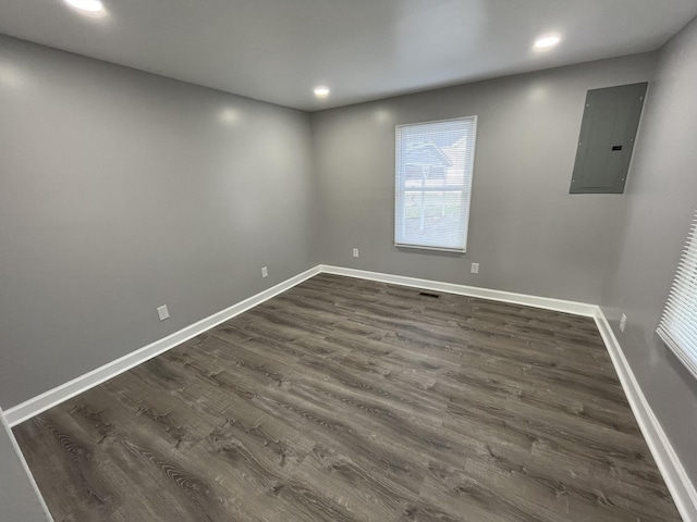 spare room featuring dark hardwood / wood-style floors and electric panel