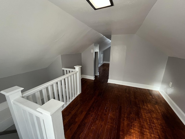 bonus room featuring dark wood-type flooring and vaulted ceiling