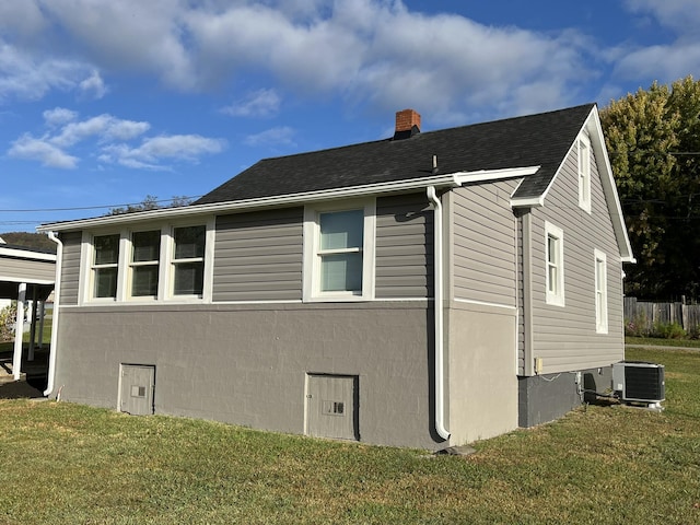 view of side of home featuring central AC and a lawn