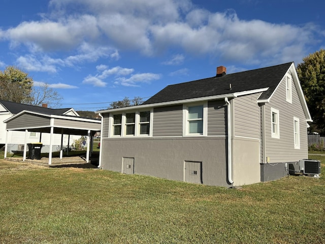 view of side of property with a carport and a yard