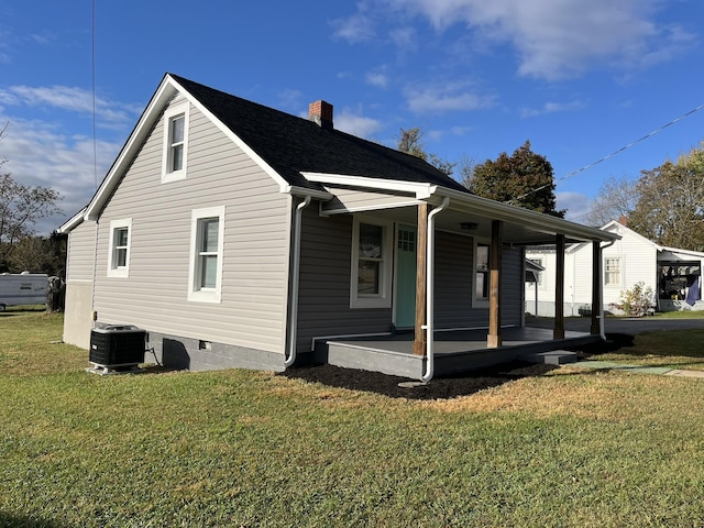 view of side of home featuring a yard, covered porch, and central air condition unit