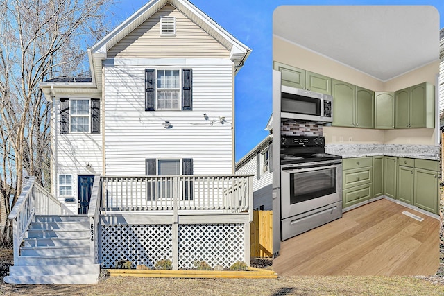 kitchen featuring stainless steel appliances, light hardwood / wood-style floors, and green cabinets