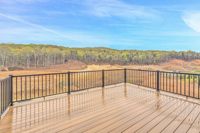 wooden terrace featuring a forest view