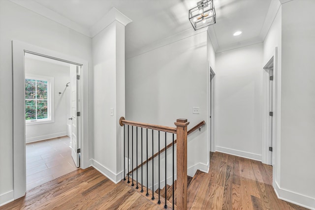 hallway with baseboards, wood finished floors, and an upstairs landing