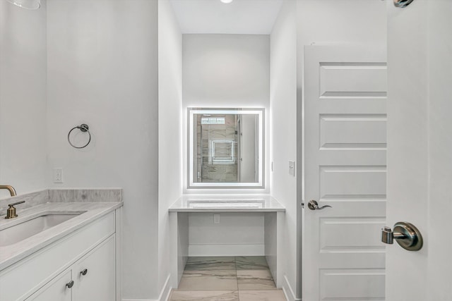 bathroom with baseboards, marble finish floor, and vanity