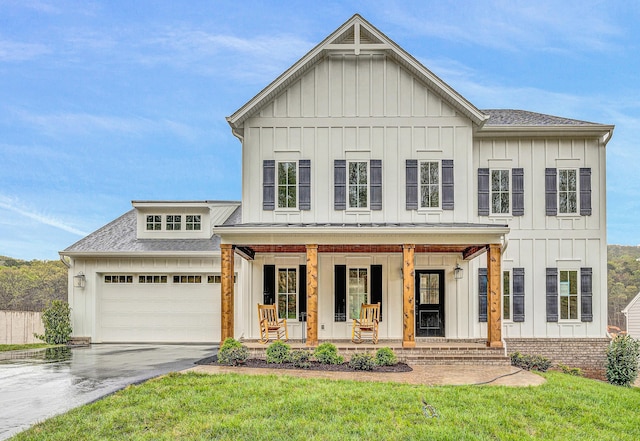 modern farmhouse with a shingled roof, board and batten siding, a porch, and driveway