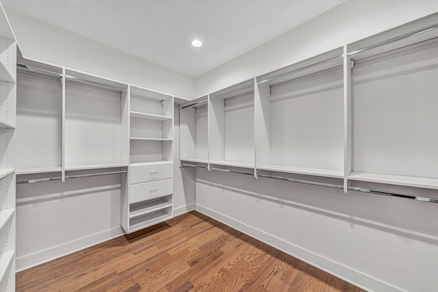 walk in closet with wood finished floors