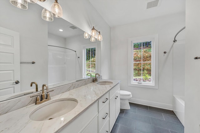 bathroom with double vanity, baseboards, a sink, and tile patterned floors