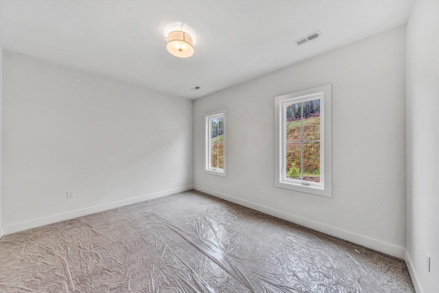 carpeted spare room with baseboards and visible vents