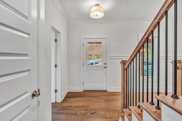 entrance foyer featuring ornamental molding, wood finished floors, and stairway