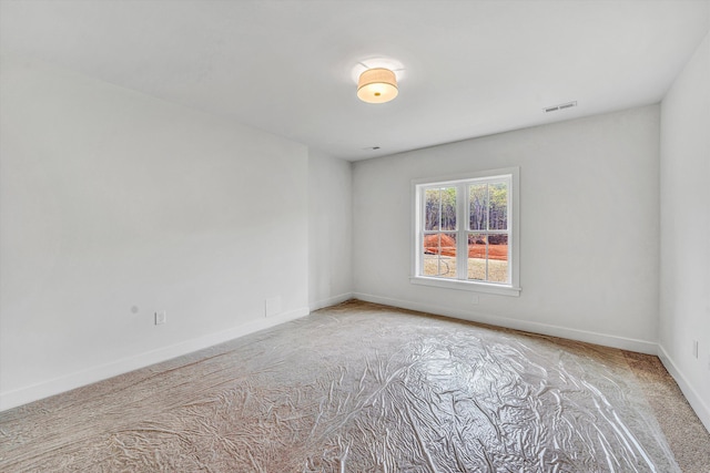 carpeted empty room featuring baseboards and visible vents