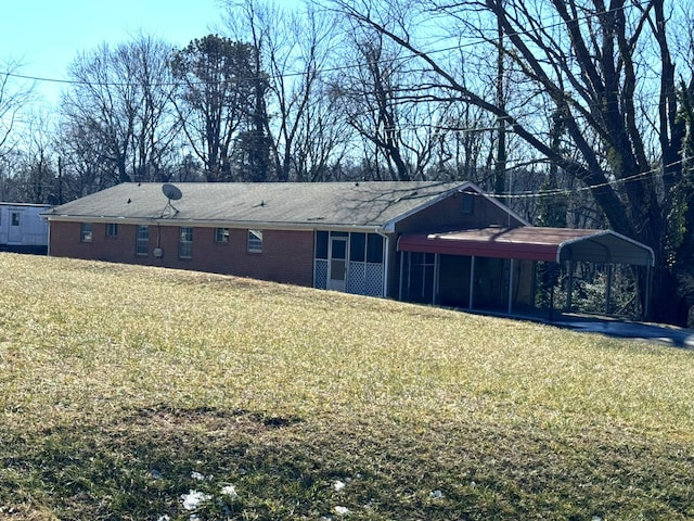 back of house with a lawn and a carport