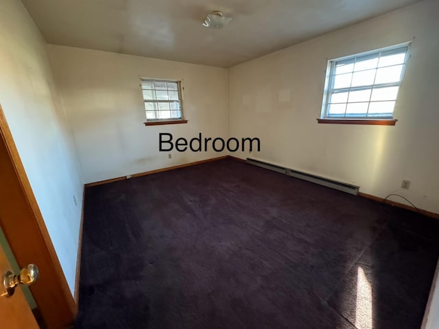 empty room featuring a baseboard radiator and carpet flooring