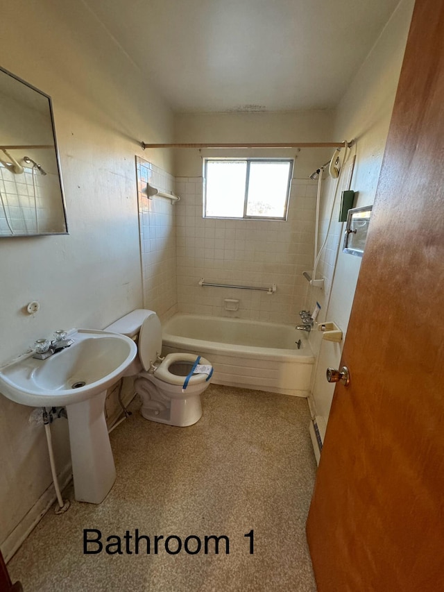 bathroom with toilet and tiled shower / bath combo