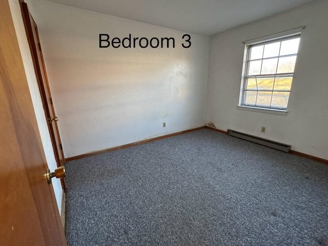 unfurnished room featuring carpet and baseboard heating