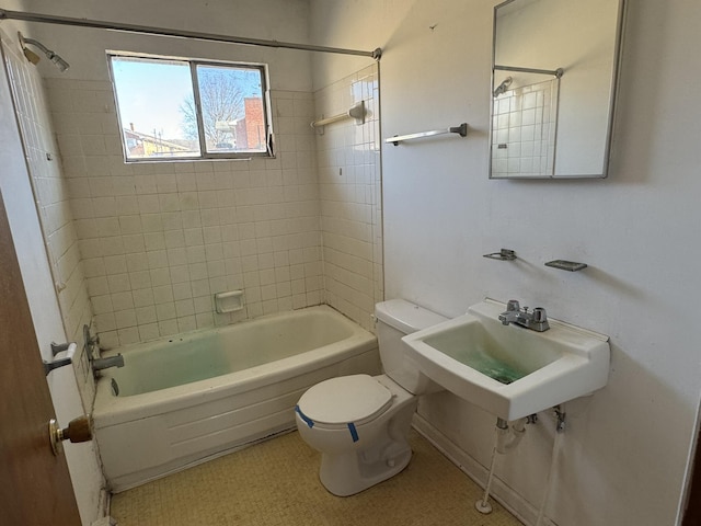 full bathroom with toilet, tiled shower / bath combo, and sink