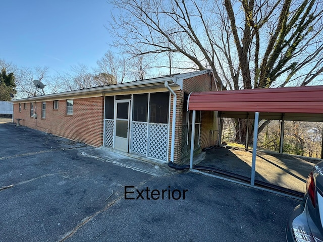 view of property exterior with a carport and a sunroom