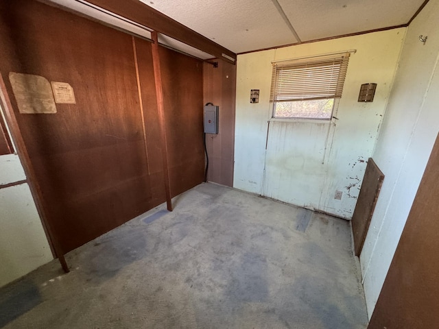 hallway featuring electric panel and concrete floors