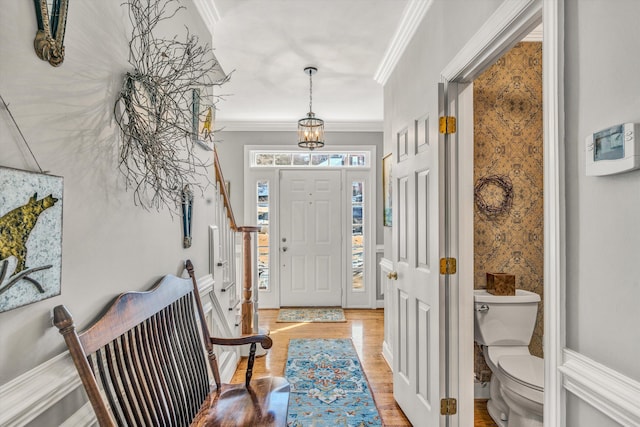 foyer entrance with crown molding and light wood-type flooring