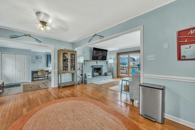 unfurnished living room with crown molding, a brick fireplace, and hardwood / wood-style floors