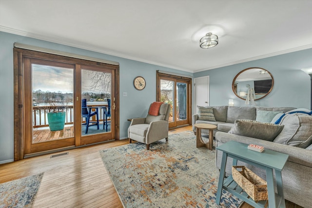 living room featuring crown molding and light hardwood / wood-style floors