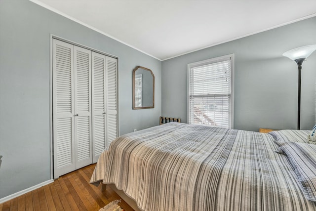 bedroom featuring hardwood / wood-style floors, ornamental molding, and a closet