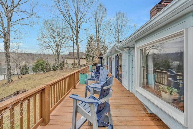 wooden deck featuring a lawn