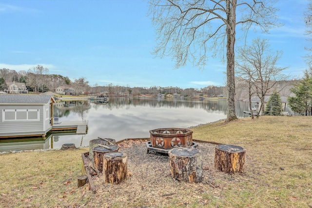 view of dock with a water view and a yard