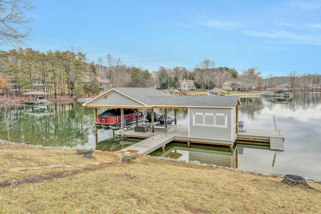 view of dock with a lawn and a water view