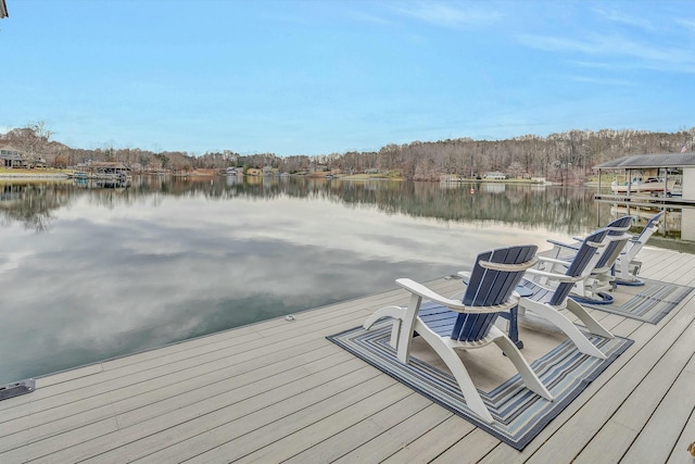 deck with a dock, ceiling fan, and a water view