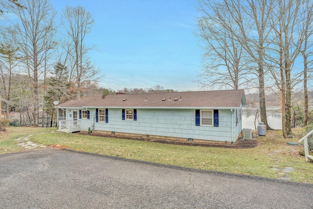 view of front of property featuring a water view, central AC, and a front lawn