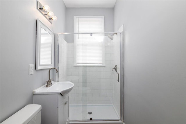 bathroom featuring vanity, toilet, and an enclosed shower