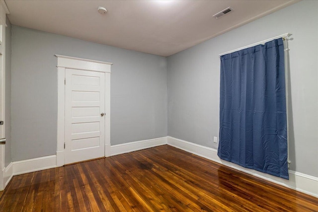 empty room with dark wood-type flooring