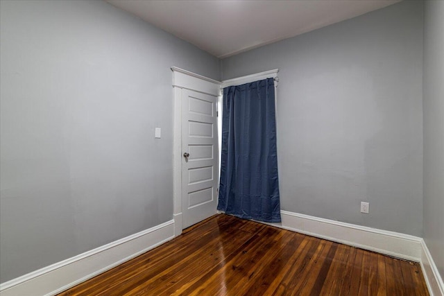 empty room with dark hardwood / wood-style flooring